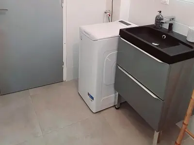 a laundry room with a sink and a washing machine at Le Marceau Cour Extérieure in Narbonne