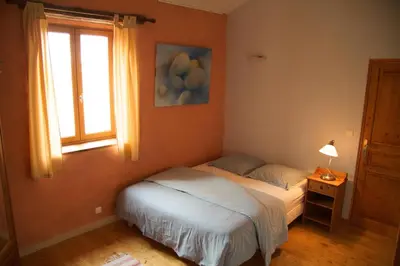 a bedroom with a bed and a window at La Maison des Couleurs in Saint-Jean-de-Paracol