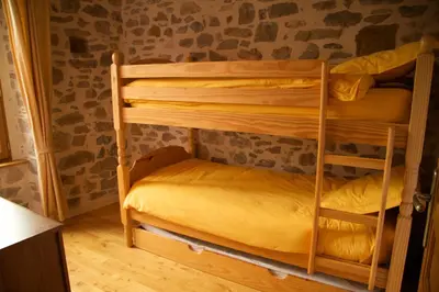 a bedroom with two bunk beds in a room at La Maison des Couleurs in Saint-Jean-de-Paracol