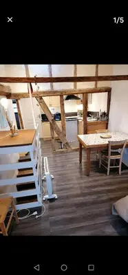 a room with a table and a table and a kitchen at bel appartement in Mirepoix