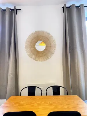 a table with chairs and a mirror on the wall at Narbonne centre Dame Nature in Narbonne