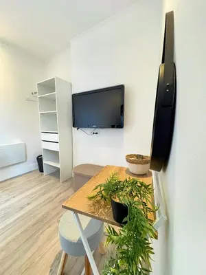 a room with a table and a tv on a wall at Narbonne centre Dame Nature in Narbonne