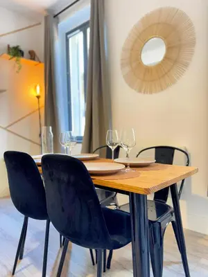 a wooden table with chairs and wine glasses at Narbonne centre Dame Nature in Narbonne