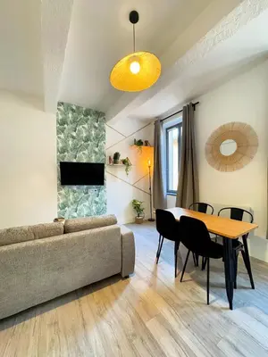 a living room with a couch and a table at Narbonne centre Dame Nature in Narbonne