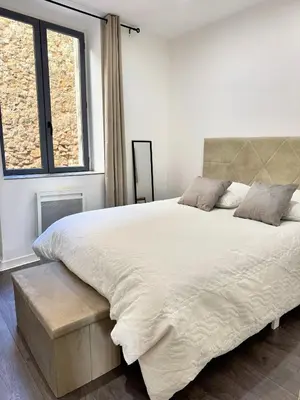 a bedroom with a large white bed and a window at Narbonne centre New york in Narbonne
