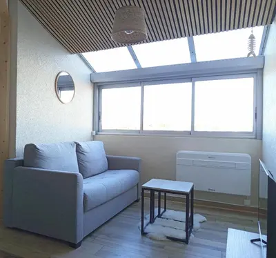a living room with a blue couch and a table at Sun Of Gruissan in Gruissan