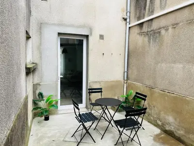 a patio with a table and chairs in a building at Henri ll l Terrasse l Proche gare & Centre ville in Castres