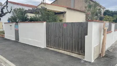 a wooden fence in front of a house at Maison 2 pièces 4 couchages PORT LA NOUVELLE PN000-042 in Port-la-Nouvelle
