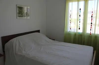 a white bed in a bedroom with a window at Maison 6 couchages - PORT LA NOUVELLE PN000-053 in Port-la-Nouvelle