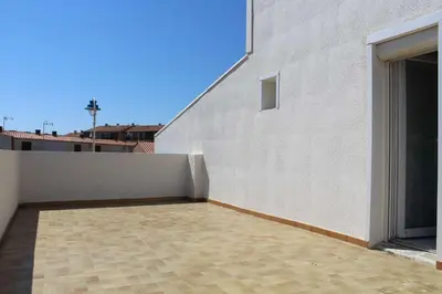 a balcony of a white building with a wall at Maison 6 couchages - PORT LA NOUVELLE PN000-053 in Port-la-Nouvelle