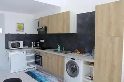 a kitchen with a washing machine and a microwave at Maison 6 couchages - PORT LA NOUVELLE PN000-053 in Port-la-Nouvelle