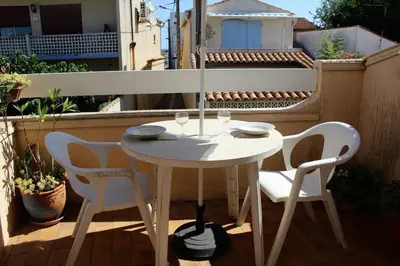 a white table and chairs on a balcony at Maison Studio mezz 2 couchages PORT LA NOUVELLE PN000-201 in Port-la-Nouvelle