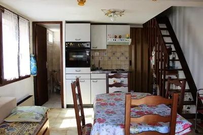 a kitchen with a table and chairs and a staircase at Maison Studio mezz 2 couchages PORT LA NOUVELLE PN000-201 in Port-la-Nouvelle
