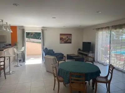 a living room with a table and chairs and a kitchen at MAISON 119m2 in Revel