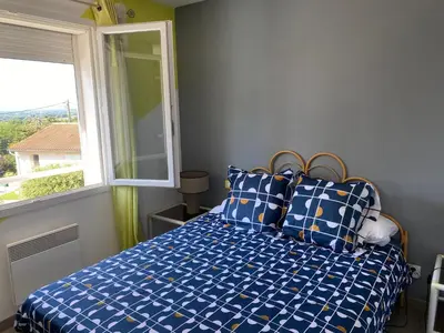 a bedroom with a blue bed with a window at MAISON 119m2 in Revel