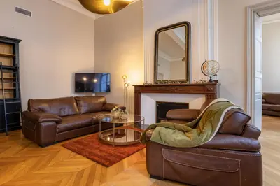 a living room with leather furniture and a mirror at L'Ecrin de Varenca in Carcassonne