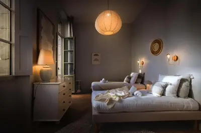 a bedroom with a bed and a couch and a lamp at L'Ecrin de Varenca in Carcassonne