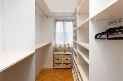 a walk in closet with white shelves and a window at L'Ecrin de Varenca in Carcassonne
