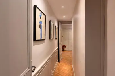 a hallway with paintings on the walls and a hallway with a door at L'Ecrin de Varenca in Carcassonne