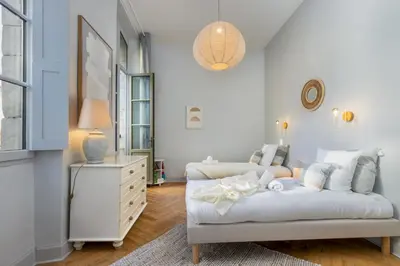 a white room with a bed and a dresser at L'Ecrin de Varenca in Carcassonne