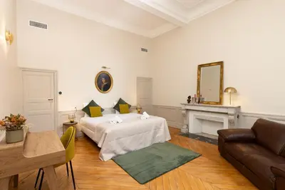 a hotel room with a bed and a couch at L'Ecrin de Varenca in Carcassonne