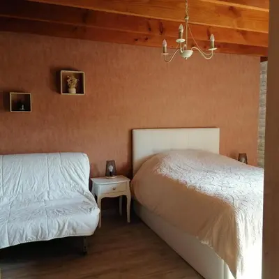 a bedroom with a bed and a night stand next to it at Gîte T3 terrasse Chalet in Puivert