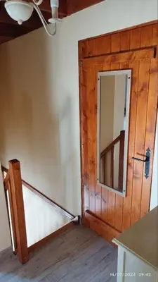 a room with a wooden door and a mirror at Gîte T3 terrasse Chalet in Puivert