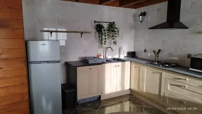 a kitchen with a white refrigerator and wooden cabinets at Gîte T3 terrasse Chalet in Puivert