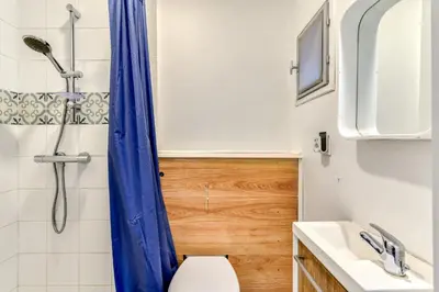 a bathroom with a blue shower curtain and a toilet at El boulangerie - Central - Wifi in Carcassonne