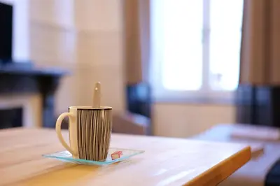 a coffee cup with a spoon on a plate on a table at Les 5 Lys in Carcassonne