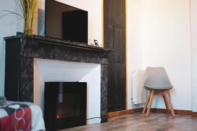 a living room with a fireplace with a tv above it at Les 5 Lys in Carcassonne