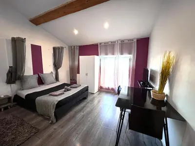 a bedroom with a bed and a desk in it at Les 5 Lys in Carcassonne