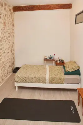 a bedroom with a bed and a black rug at Maison village T5 in Fitou