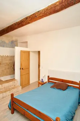 a bedroom with a bed with a blue comforter at Maison village T5 in Fitou