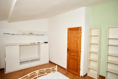 a room with white walls and a door and shelves at Maison village T5 in Fitou