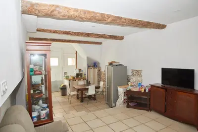 a living room with a tv and a dining room at Maison village T5 in Fitou