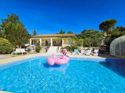 a swimming pool with two pink flamingos in the water at Les Hirondelles in Beaufort