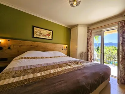 a bedroom with a bed and a large window at Les Hirondelles in Beaufort