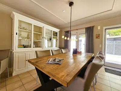 a dining room with a wooden table and chairs at Les Hirondelles in Beaufort