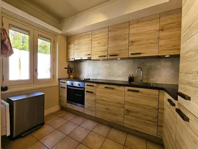 a kitchen with wooden cabinets and a sink at Les Hirondelles in Beaufort
