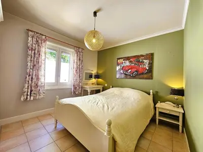 a bedroom with a bed with a painting of a car on the wall at Les Hirondelles in Beaufort