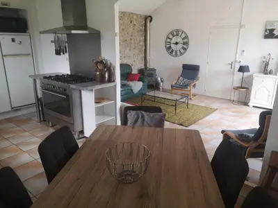 a kitchen and living room with a wooden table at Villa L'Oustalet in Douzens
