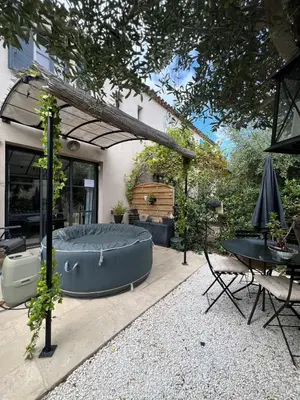 a backyard with a hot tub and a table at Maison T3 avec spa in Saint-Laurent-de-la-Cabrerisse