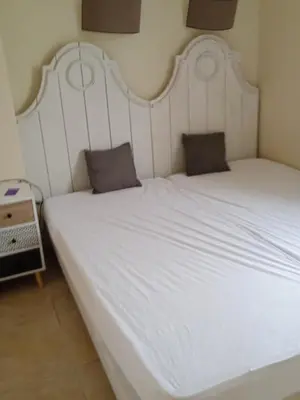a large white bed with two pillows on it at Maison T3 avec spa in Saint-Laurent-de-la-Cabrerisse