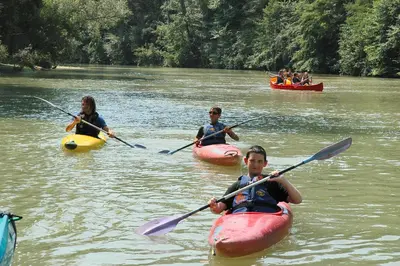 a group of people kayaking on a river at La Bastide in Mazères