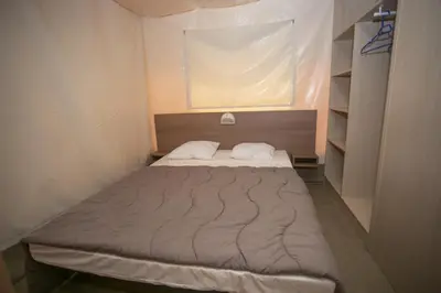 a small bed in a small room with a window at La Bastide in Mazères