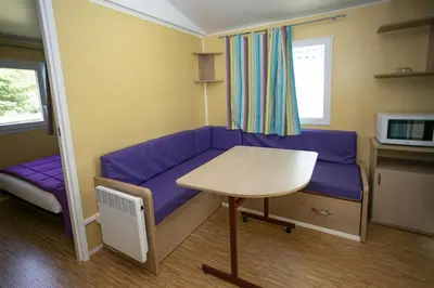 a living room with a purple couch and a table at La Bastide in Mazères