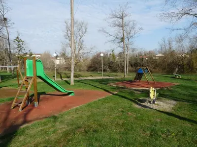 a park with two swings and a slide at La Bastide in Mazères