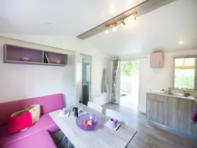 a living room with a pink couch and a table at La Bastide in Mazères