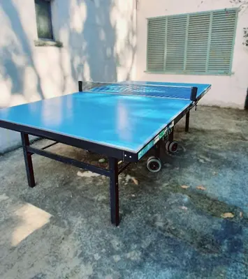 a blue ping pong table in front of a building at L'ECRIN DU LAC - Ô Cèpes in Mazamet